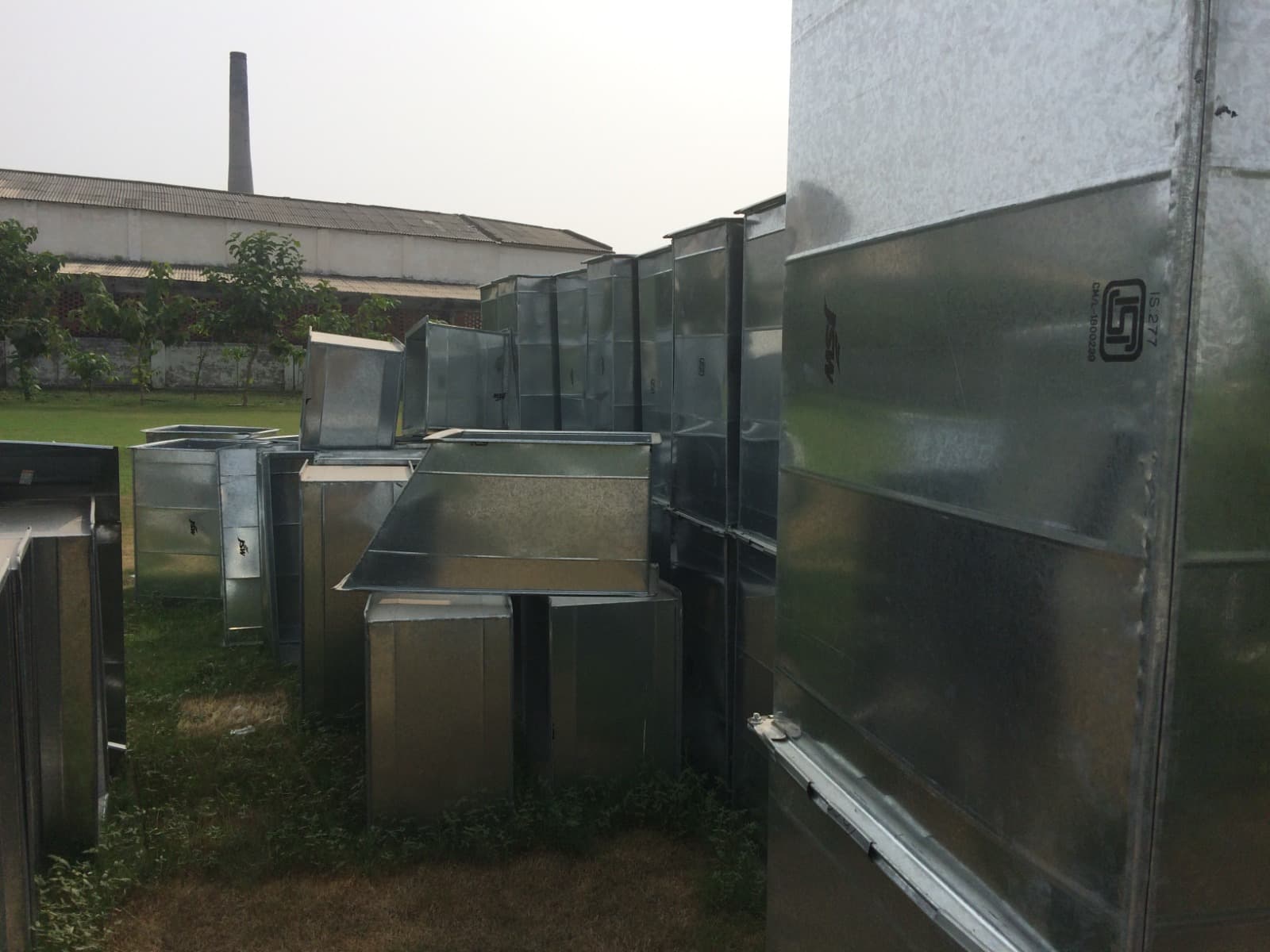 IS 277 marked galvanised duct sections and fittings stored in the yard