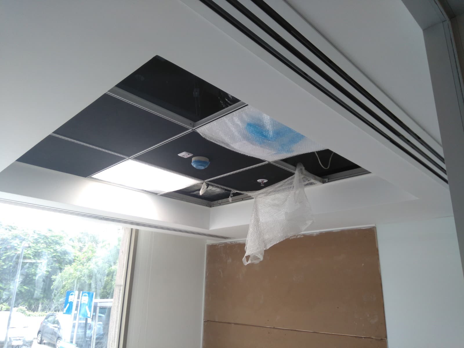 Glossy black grid false ceiling with concealed sprinklers during installation