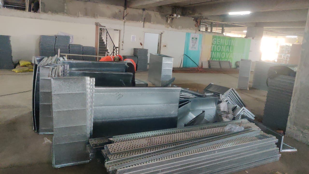Fabricated GI duct sections and cable trays staged at a project site