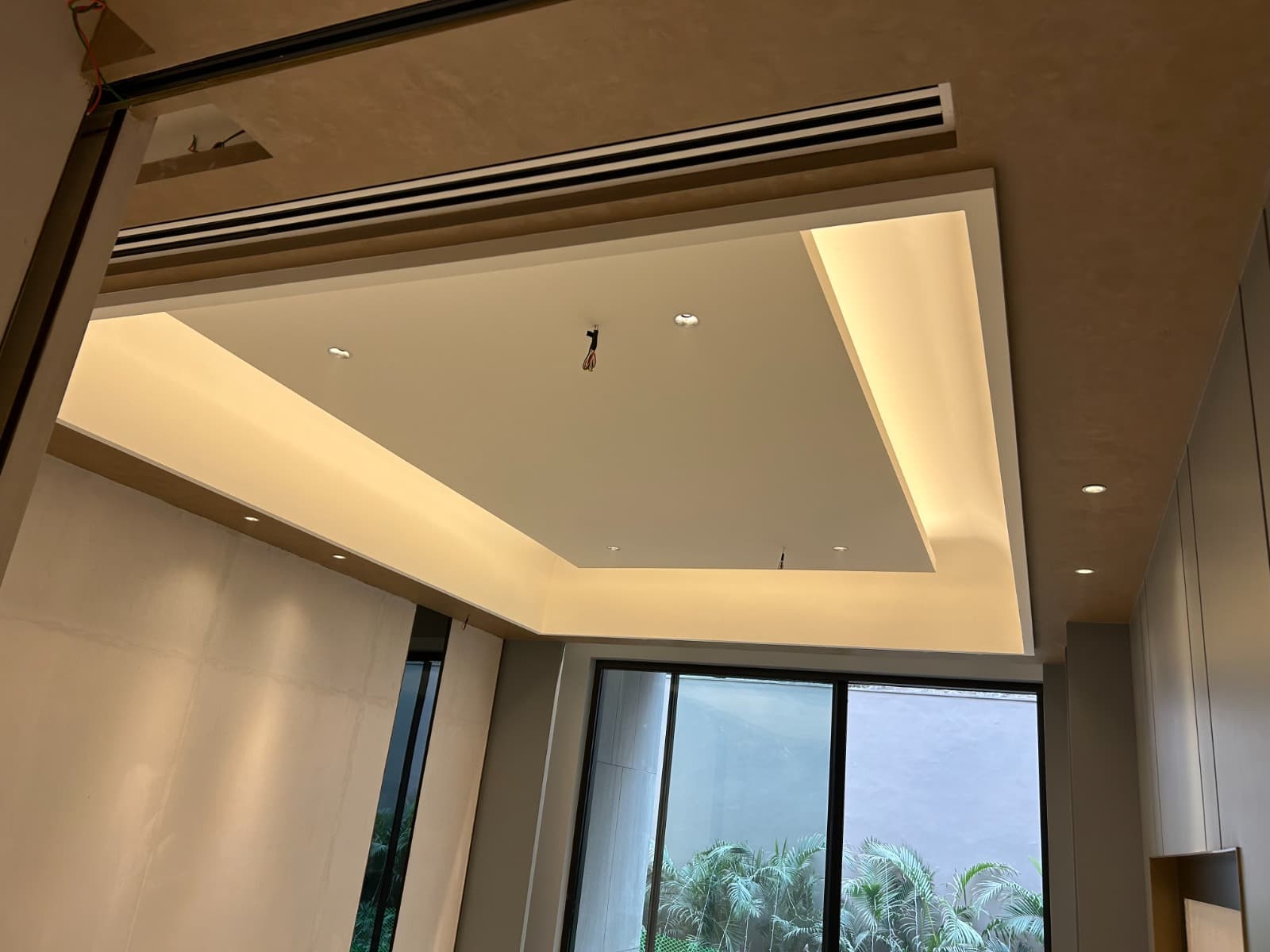 Premium cove-lit false ceiling with recessed downlights in a finished interior