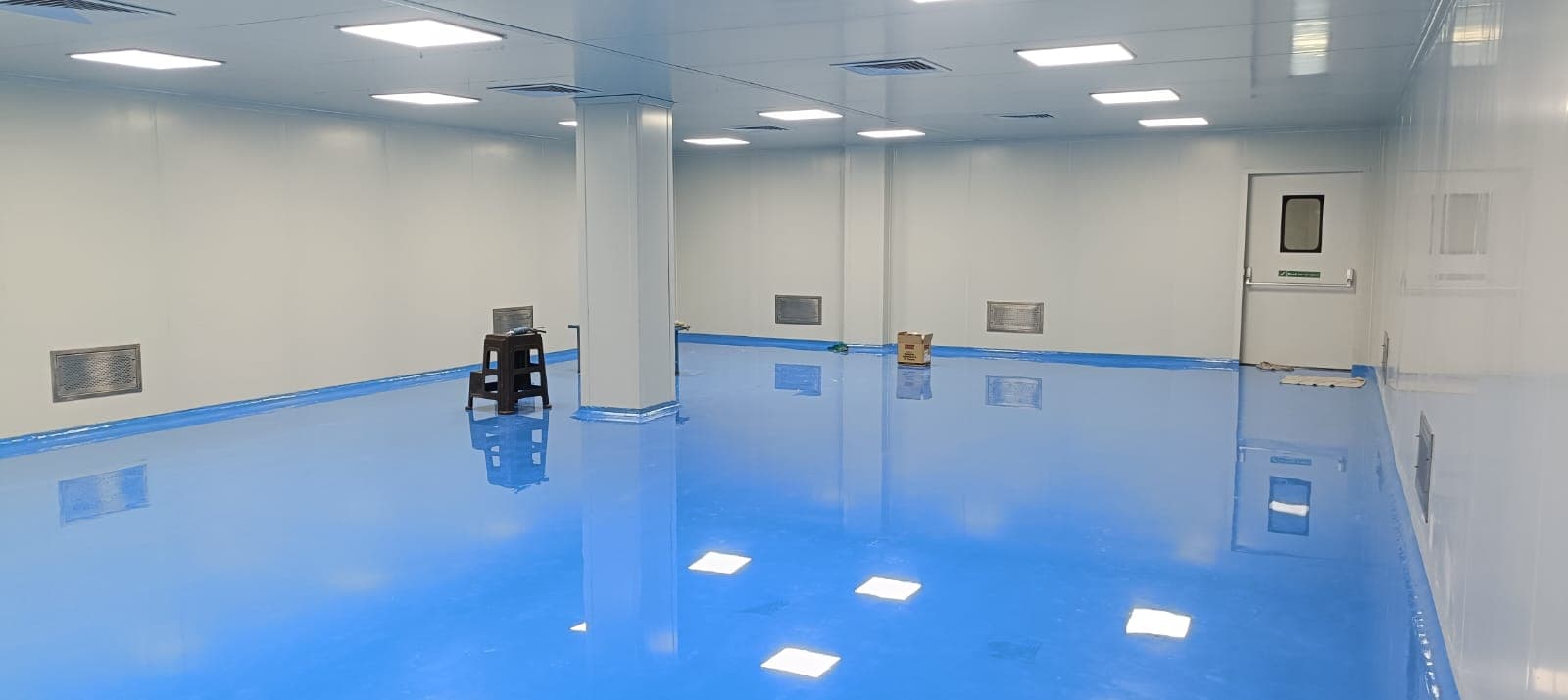 Cleanroom production hall with blue epoxy floor, PUF-panel walls and clean-room LED luminaires
