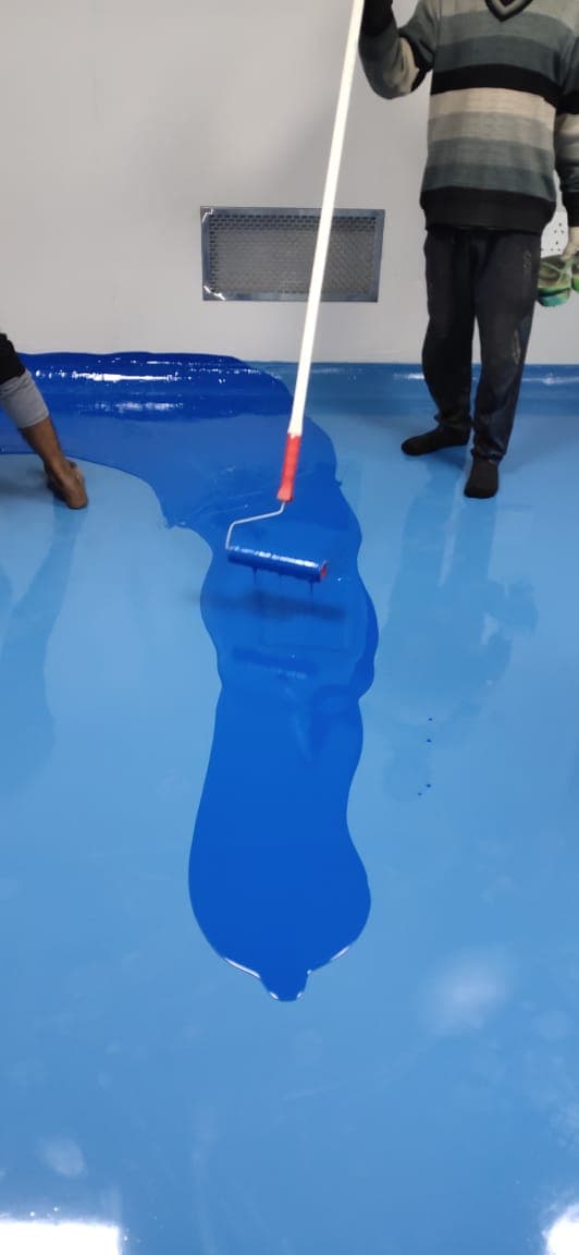 Rolling blue self-levelling epoxy floor coating in a cleanroom